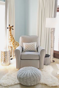 a baby's room with a giraffe in the background and a chair