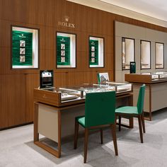 a jewelry store with wooden walls and green chairs in front of the counter top area