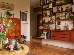 a living room filled with lots of furniture and flowers in vases on top of a coffee table