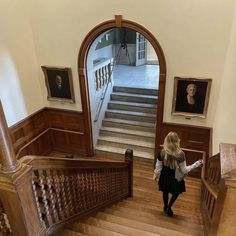 a woman is walking down the stairs in an old building