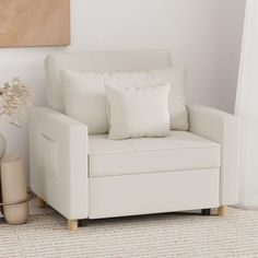 a living room with a white couch and some vases on the floor next to it