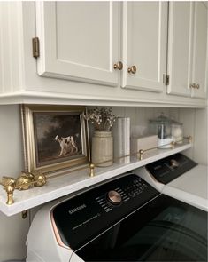 a white washer and dryer sitting in a room next to some cupboards