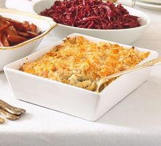 several dishes of food on a table with utensils