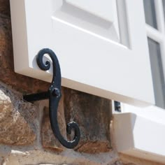 an iron hook on the side of a stone building