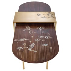 an artistically designed wooden table with birds and flowers on the top, against a white background