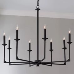 a black chandelier with eight candles hanging from it