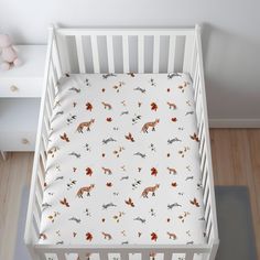 a baby crib bed with a fox print on the sheet and pillowcase cover