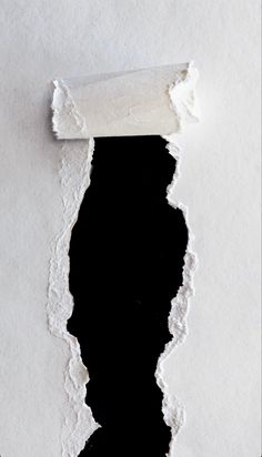 a torn piece of white paper with black background