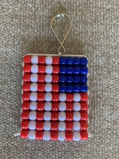 an ornament made out of red, white and blue beads on the floor