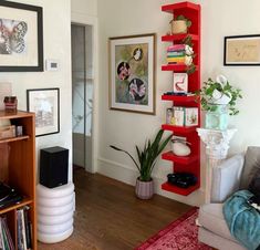 a living room filled with furniture and bookshelves next to a wall covered in pictures