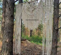 there is a white macrame hanging in the woods