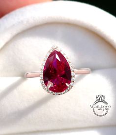 a close up of a ring with a large red stone in it's center