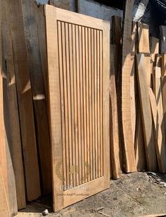 several wooden boards stacked on top of each other in front of a pile of wood planks