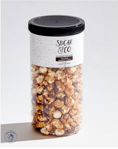 a jar filled with nuts sitting on top of a white table next to a black lid