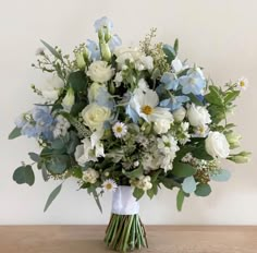 a bouquet of white and blue flowers on a table