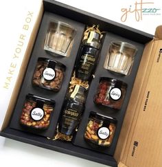 an open gift box containing six jars of nuts and other condiments in it