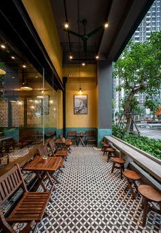 an empty restaurant with wooden benches and tables in front of large windows that overlook the city