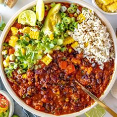 a bowl filled with chili, corn and rice next to two bowls of mexican food