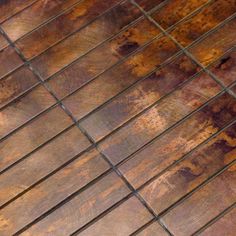 a close up view of an old wooden floor with rusted metal grates on it