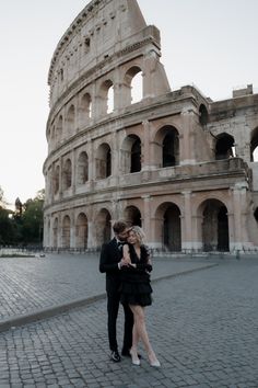 a man and woman standing in front of an old building