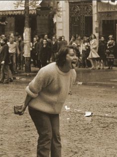 an old black and white photo of a man on a skateboard in front of a crowd