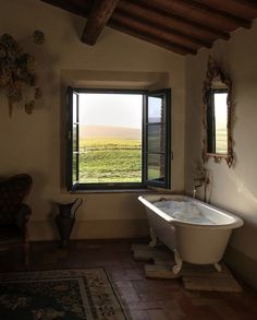 a bath tub sitting next to a window in a bathroom