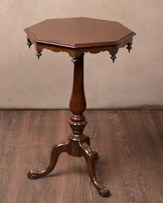 a small wooden table with an octagonal top on it's legs and turned to the side