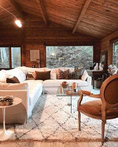 a living room filled with lots of furniture next to a large window covered in wood