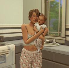 a woman holding a baby in her arms while standing next to a stove top oven