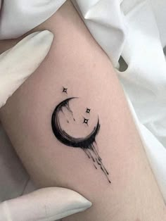 a woman's arm with a crescent and stars tattoo on it