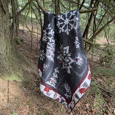 a black and white blanket hanging from a tree