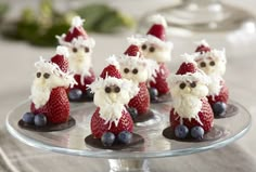 some little santa clause figurines on a glass plate