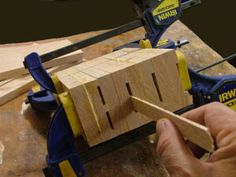 a person using a jik to cut wood with a power tool on a workbench