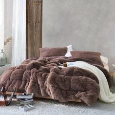 a bed covered in brown fur next to a window