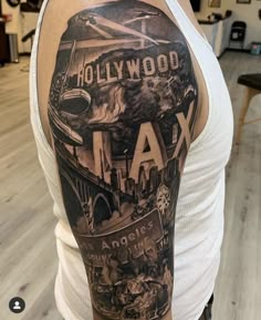 a man with a tattoo on his arm that says hollywood and an image of the los angeles skyline