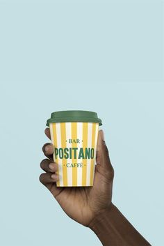 a hand holding up a coffee cup with the words fair positanoo cafe on it