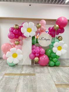 the balloon arch is decorated with flowers and balloons