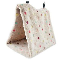 a white blanket with multicolored dots hanging from it's hook on the wall