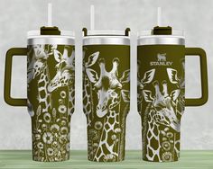 three travel mugs with giraffes on them sitting next to each other