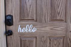 a wooden door with the word hello painted on it's side and an electronic lock