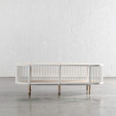 a white bench sitting on top of a cement floor