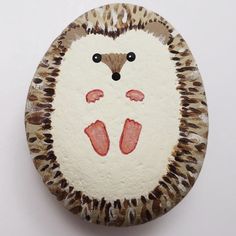 a painted rock with an animal face on it's side and feet in the middle