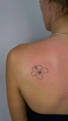 a woman with a flower tattoo on her back