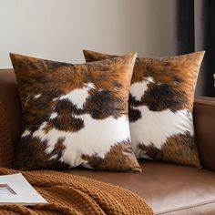 two brown and white pillows sitting on top of a couch