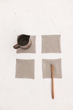 four pieces of cloth and a wooden spoon on a white surface with one piece cut out