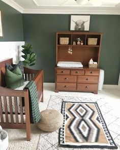 a baby's room with green walls and furniture