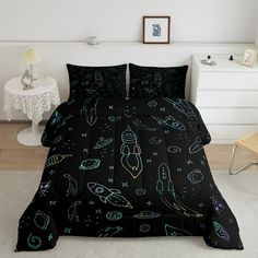 a bed with black and green space themed comforter sets on it in a white room