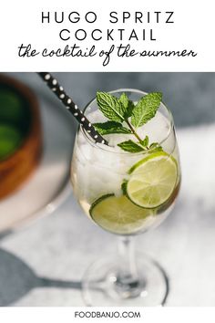 a glass filled with ice and lime on top of a table