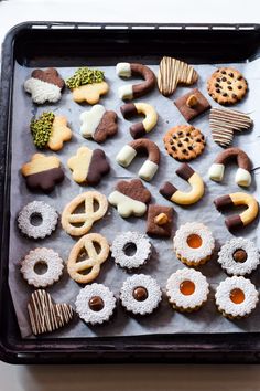 a tray filled with assorted cookies and pretzels on top of a table