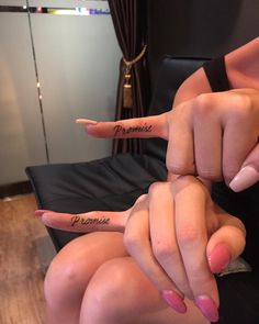 two people with their fingers in the shape of numbers on their thumbnails, and one is pointing at something